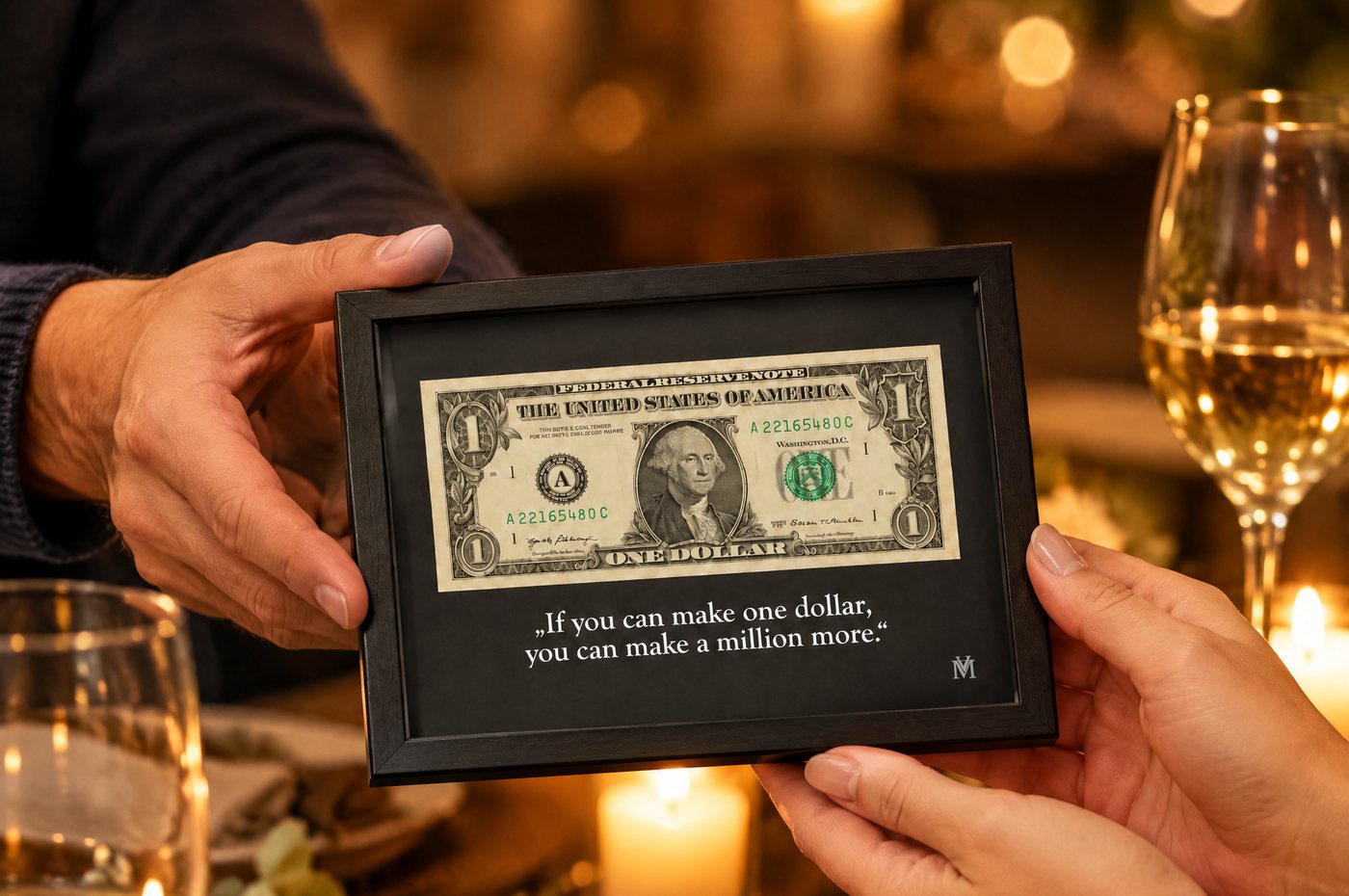 Ein Mensch überreicht einem anderen den gerahmten Dollar am Esstisch